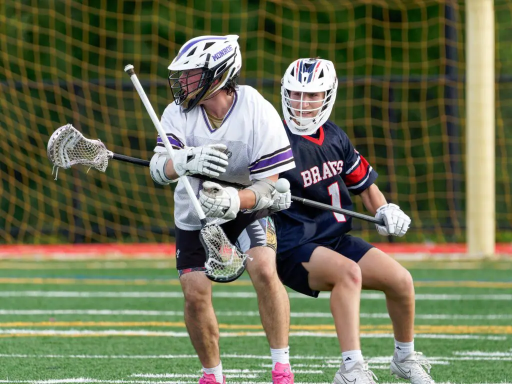 Manalapan senior Dennis Gabinelli knocks the stick out of the hands of a Monroe player with a well-timed check during the Braves' 8-6 win in the first round of the 2025 NJSIAA South Group 4 boys lacrosse state tournament. (Bob Badders | rpbphotography.com).